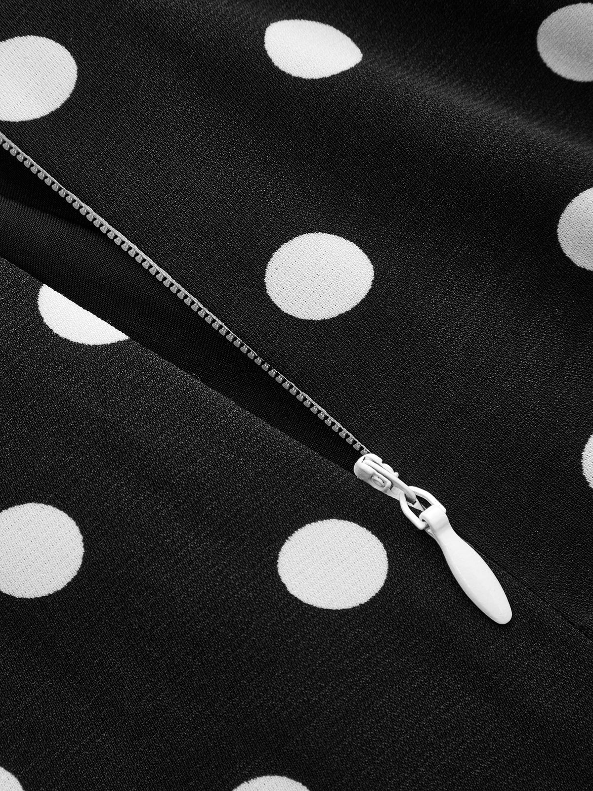 Detail van de V-hals en stippenprint van de dames maxi jurk