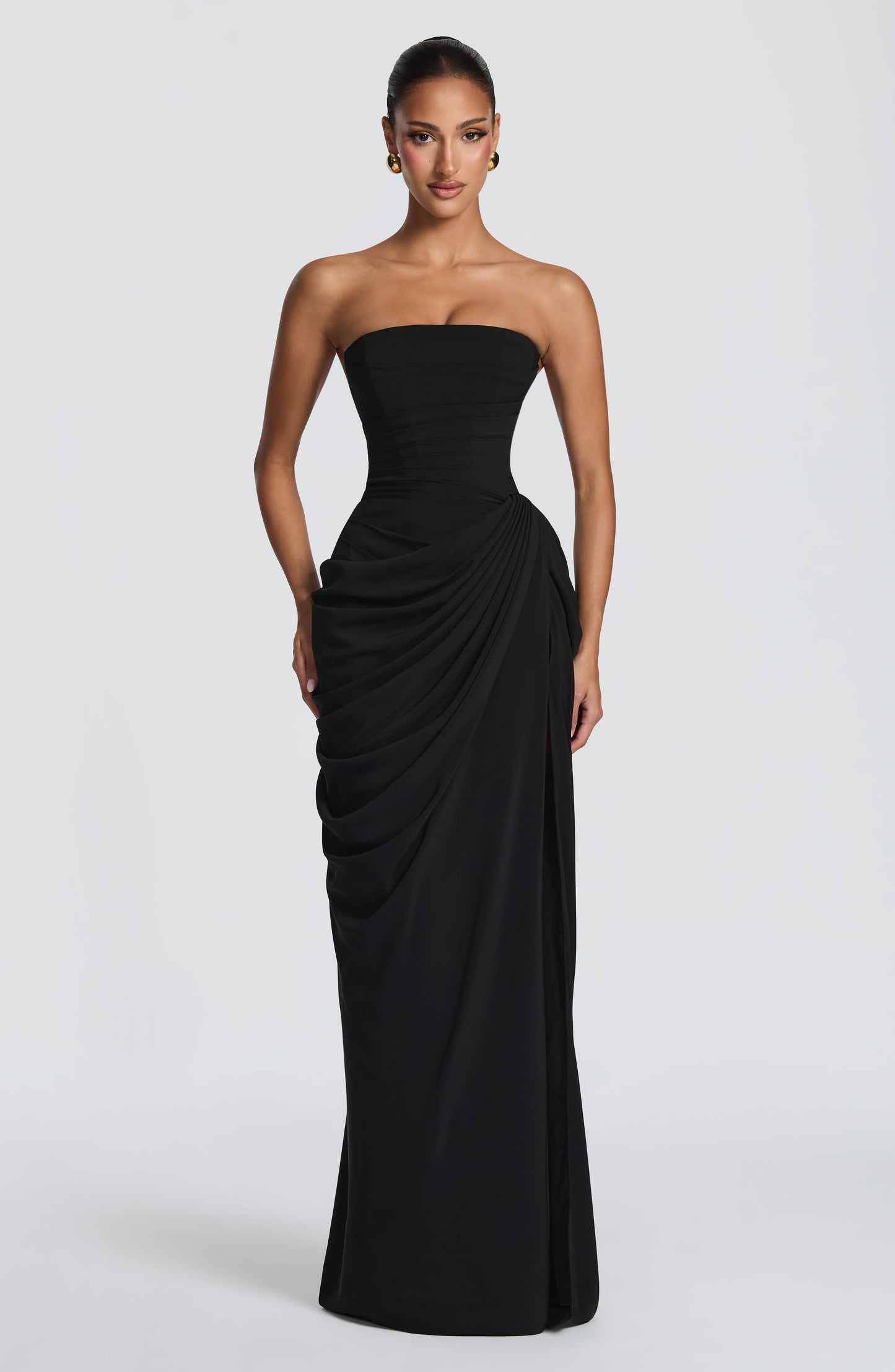 Damesmodel in een elegante straploze maxi jurk met vloeiende pasvorm