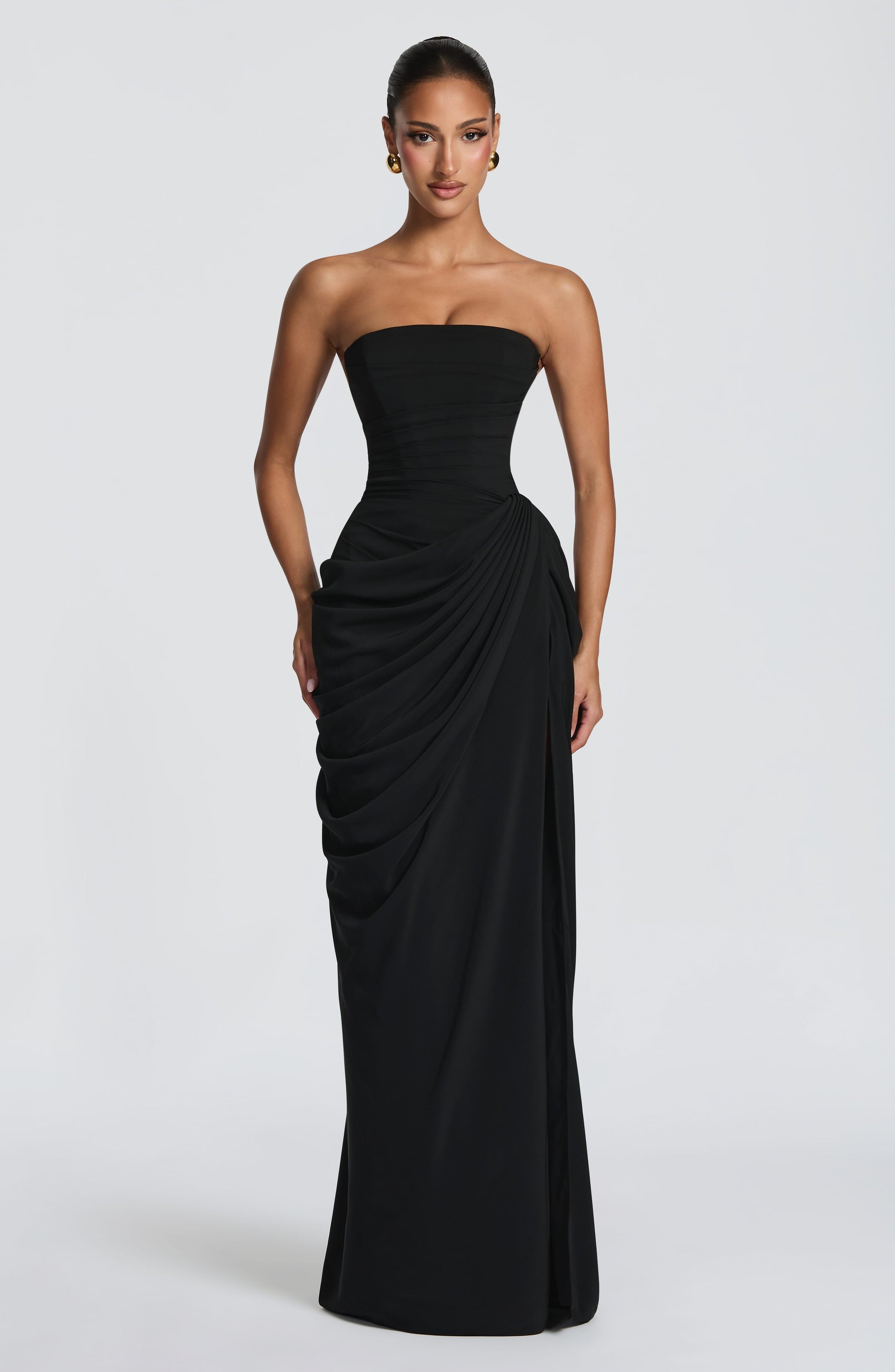 Damesmodel in een elegante straploze maxi jurk met vloeiende pasvorm