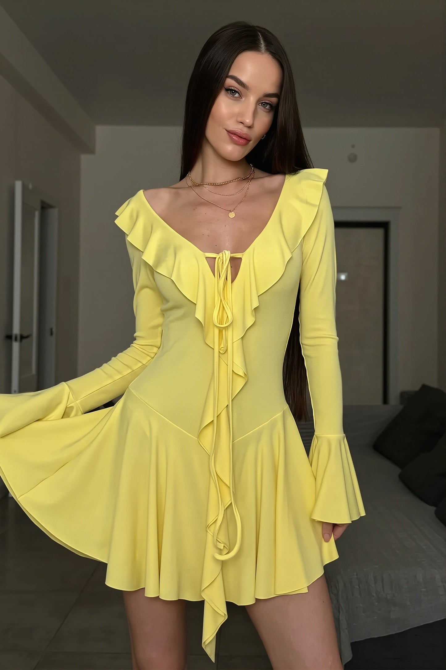 Dames bodycon mini jurk met uitlopende mouwen in elegante pose