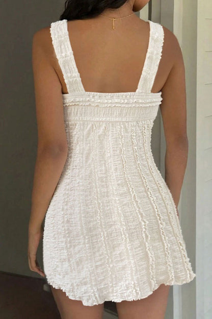 Detail van de witte mini jurk met ruches, textuurstof en strikschouders