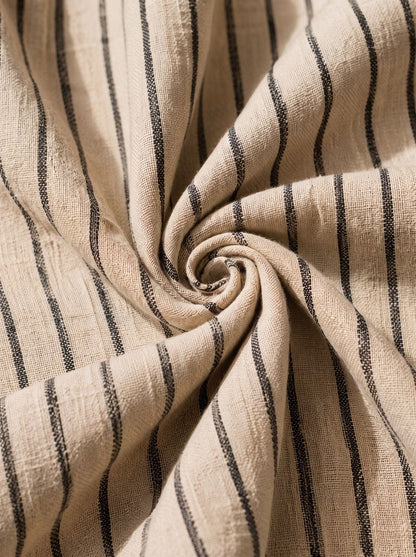 Detail van de off-shoulder halslijn van de gestreepte damesjurk.